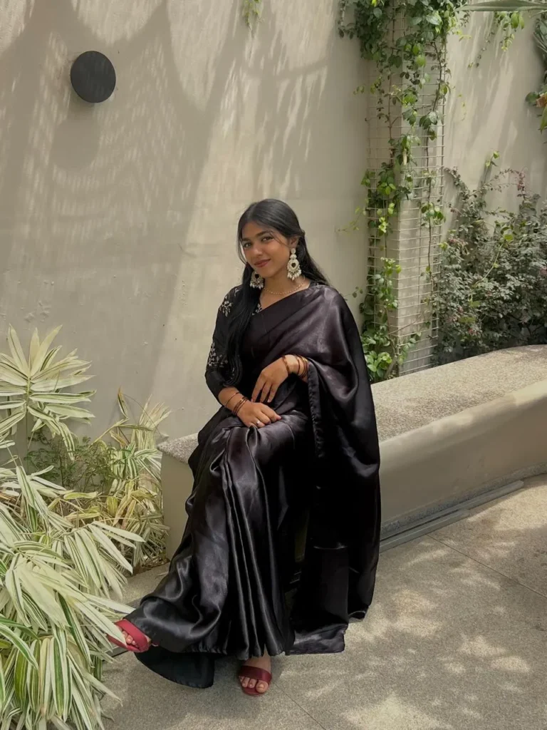 A confident young woman in a stylish black saree, representing the elegance and professionalism of the best freelance digital marketer in Delhi.